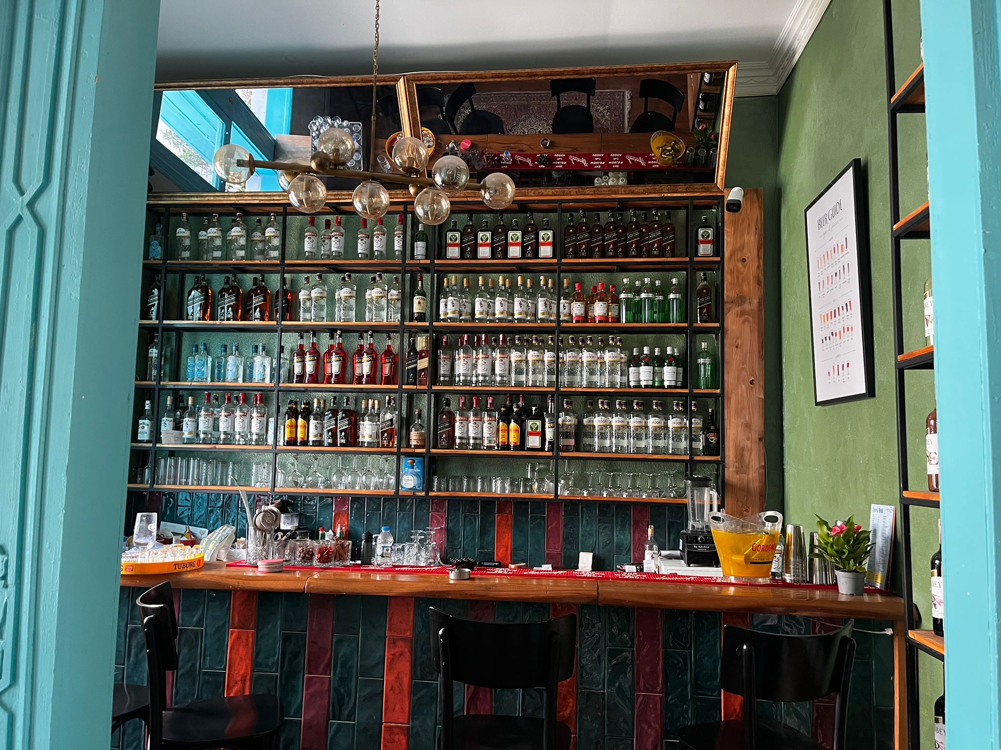 Adaçayı yeşili duvarlı bar rafı ve servis istasyonu
